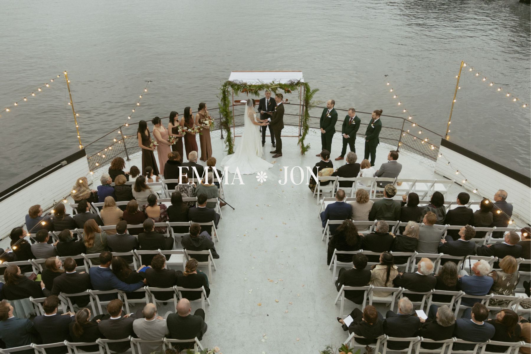 Overhead view of a Seattle wedding ceremony aboard the MV Skansonia, with guests seated on the deck and the couple exchanging vows over the water.