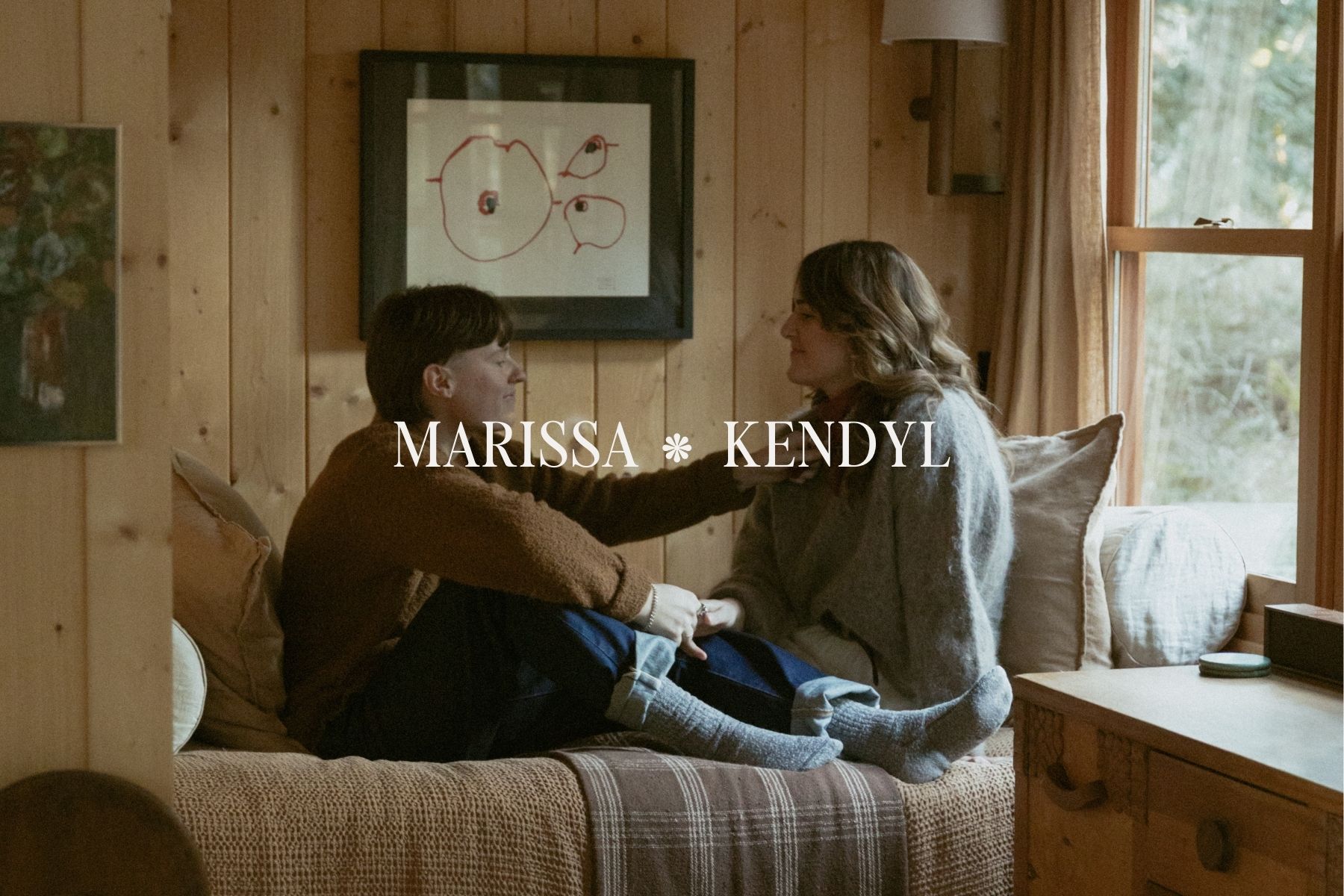 Couple sitting together on a cozy cabin couch during a couples session at a tiny Airbnb in Olympia, Washington.